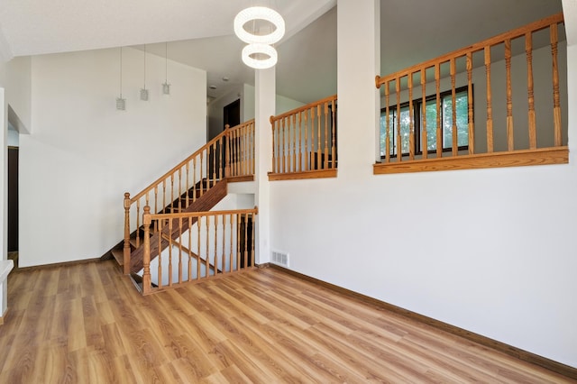 8341 Abbott Ave N, Brooklyn Park, MN 55443 - staircase with wood finished floors, a high ceiling, and a chandelier