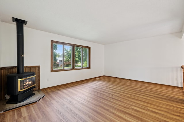 8341 Abbott Ave N, Brooklyn Park, MN 55443 - unfurnished living room featuring a wood stove and wood finished floors