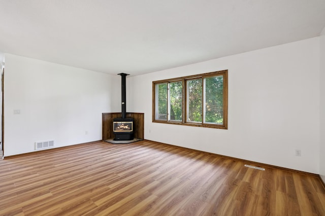8341 Abbott Ave N, Brooklyn Park, MN 55443 - unfurnished living room featuring light wood-style floors and a wood stove
