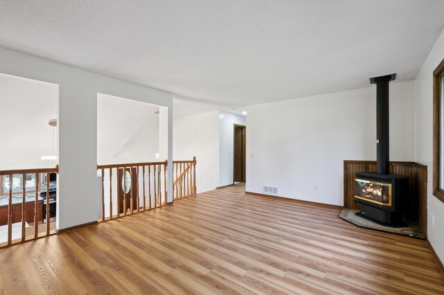 8341 Abbott Ave N, Brooklyn Park, MN 55443 - unfurnished living room featuring wood finished floors and a wood stove