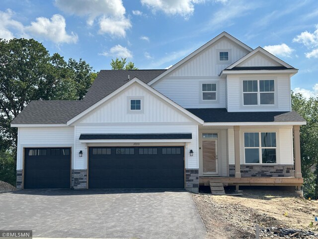 17233 61st St NE, Otsego, MN 55374 - view of front of property with driveway, stone siding, board and batten siding, and roof with shingles