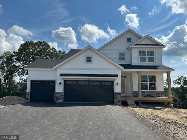 17233 61st St NE, Otsego, MN 55374 - view of front facade with driveway, stone siding, board and batten siding, and a porch