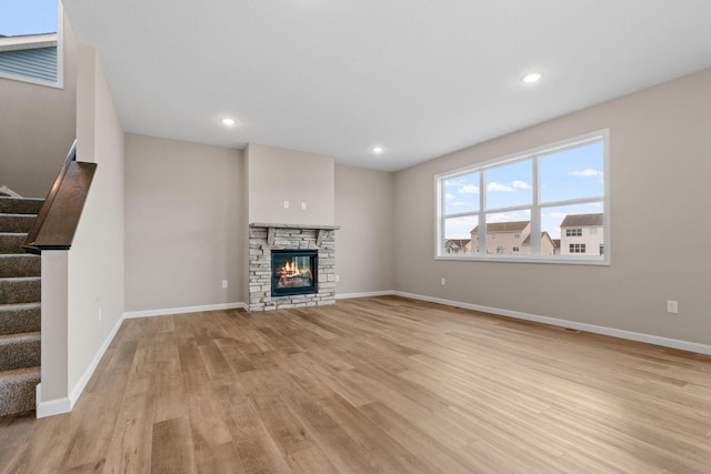 17233 61st St NE, Otsego, MN 55374 - unfurnished living room with stairs, wood finished floors, recessed lighting, and a stone fireplace