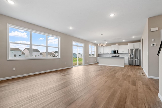 17233 61st St NE, Otsego, MN 55374 - unfurnished living room with a chandelier, recessed lighting, and light wood-style flooring