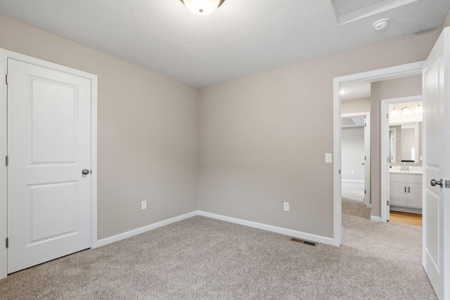 17233 61st St NE, Otsego, MN 55374 - unfurnished bedroom with light carpet, a textured ceiling, and ensuite bathroom