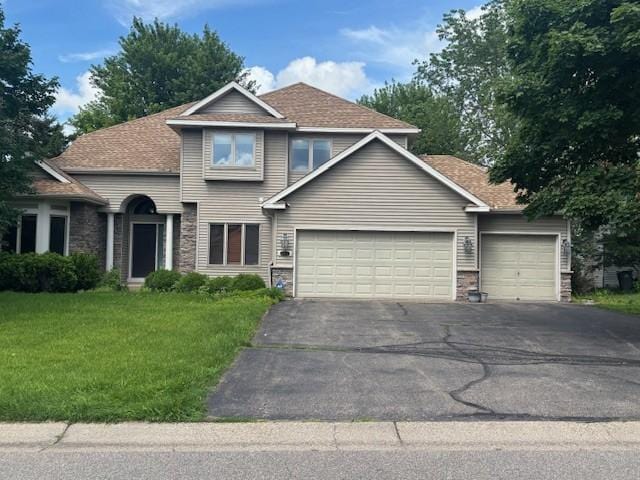 12452 Alise Pl, Eden Prairie, MN 55347 - view of front of home with an attached garage, driveway, a front yard, stone siding, and roof with shingles