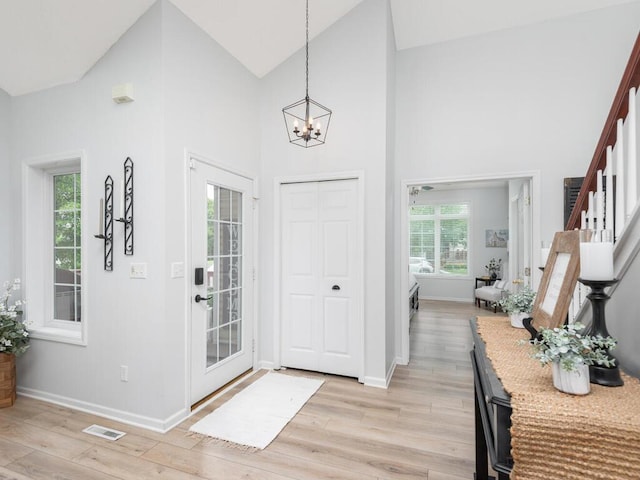 2606 Boulder Way, Burnsville, MN 55337 - foyer entrance with a chandelier, light wood finished floors, high vaulted ceiling, and stairway