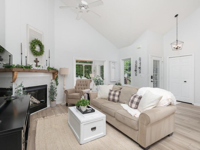 2606 Boulder Way, Burnsville, MN 55337 - living room with high vaulted ceiling, light wood finished floors, a chandelier, a fireplace, and a ceiling fan