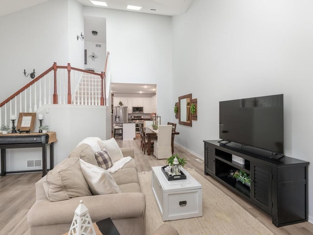 2606 Boulder Way, Burnsville, MN 55337 - living area featuring a high ceiling, light wood-style flooring, and stairway