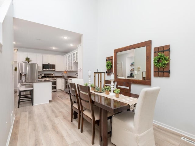 2606 Boulder Way, Burnsville, MN 55337 - dining space featuring light wood-style flooring, recessed lighting, and a towering ceiling