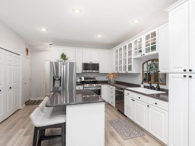 2606 Boulder Way, Burnsville, MN 55337 - kitchen featuring appliances with stainless steel finishes, a breakfast bar area, a center island, glass insert cabinets, and white cabinetry