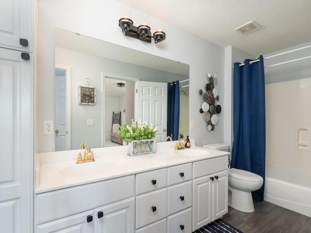 2606 Boulder Way, Burnsville, MN 55337 - bathroom with double vanity, wood finished floors, shower / bath combo with shower curtain, and a textured ceiling