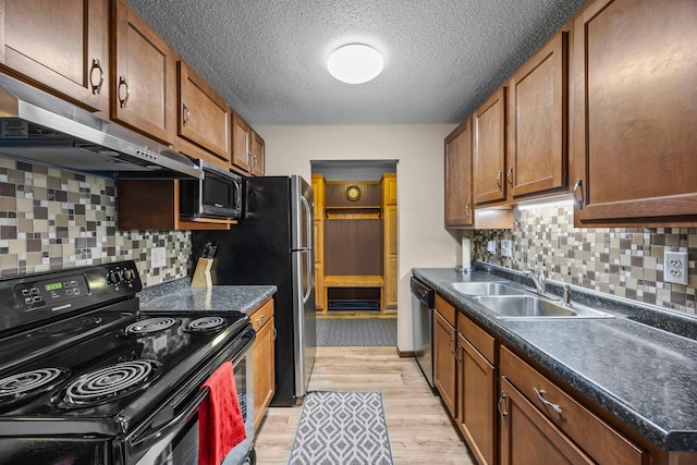 30675 Park St Unit 209, Lindstrom, MN 55045 - kitchen with black electric range, under cabinet range hood, stainless steel microwave, light wood-style flooring, and dark countertops