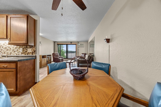 30675 Park St Unit 209, Lindstrom, MN 55045 - dining space featuring a textured ceiling, a textured wall, a ceiling fan, and light wood-style floors