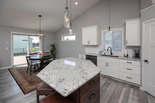3875 Virgo Ln SW, Rochester, MN 55902 - kitchen featuring a chandelier, backsplash, a kitchen island, light stone counters, and high vaulted ceiling