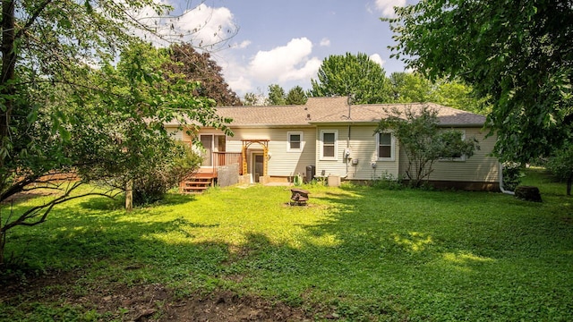 507 15th St SE, Menomonie, WI 54751 - back of property featuring a wooden deck, an outdoor fire pit, a yard, and a shingled roof