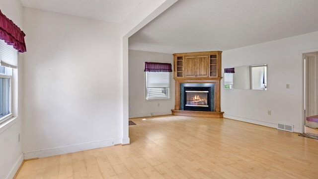 507 15th St SE, Menomonie, WI 54751 - unfurnished living room featuring healthy amount of natural light, wood finished floors, and a fireplace