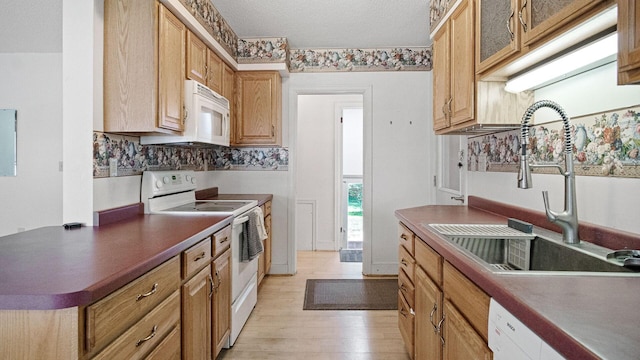 507 15th St SE, Menomonie, WI 54751 - kitchen with white appliances, light wood-style flooring, dark countertops, glass insert cabinets, and backsplash