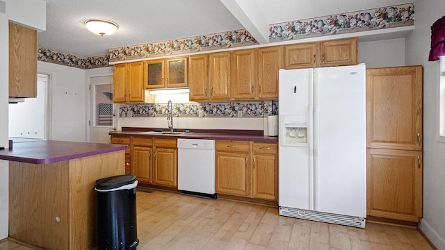 507 15th St SE, Menomonie, WI 54751 - kitchen with white appliances, dark countertops, light wood-type flooring, and glass insert cabinets