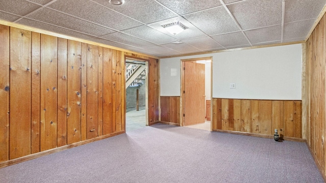 507 15th St SE, Menomonie, WI 54751 - carpeted empty room with wood walls, a wainscoted wall, and stairway