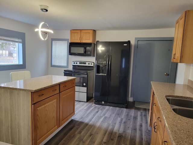 1410 5th St, Saint Paul Park, MN 55071 - kitchen featuring black appliances, dark wood finished floors, light stone countertops, a center island, and pendant lighting