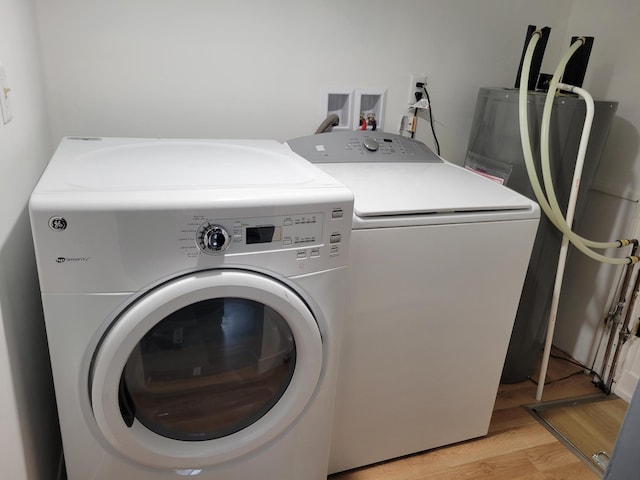 1410 5th St, Saint Paul Park, MN 55071 - washroom featuring washing machine and clothes dryer, light wood-style floors, and water heater