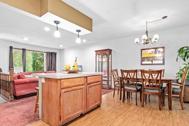 5781 Needham Ave NE, Saint Michael, MN 55376 - kitchen with light wood-type flooring, light countertops, decorative light fixtures, a kitchen island, and recessed lighting