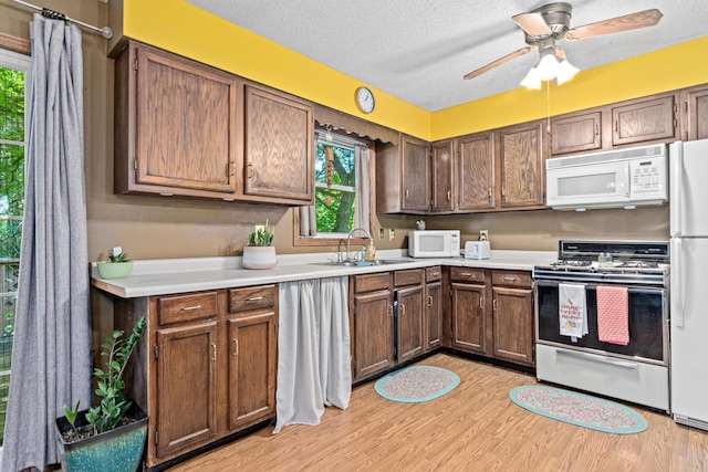 5781 Needham Ave NE, Saint Michael, MN 55376 - kitchen featuring white appliances, light countertops, light wood-type flooring, ceiling fan, and a textured ceiling