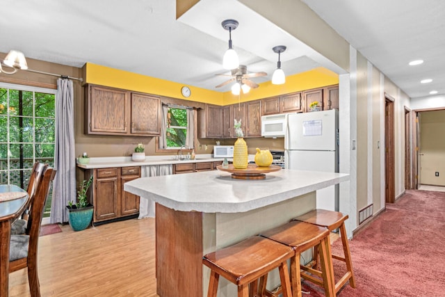 5781 Needham Ave NE, Saint Michael, MN 55376 - kitchen featuring white microwave, light countertops, a kitchen breakfast bar, decorative light fixtures, and recessed lighting
