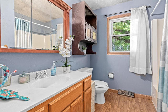 5781 Needham Ave NE, Saint Michael, MN 55376 - bathroom with a textured ceiling, vanity, wood finished floors, and shower / bath combo with shower curtain