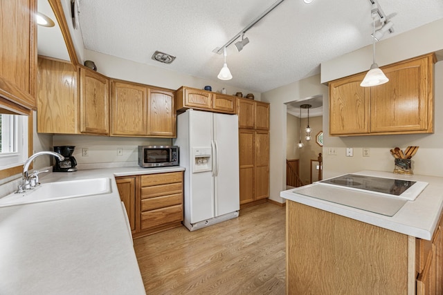 487 Lois Ln, Lino Lakes, MN 55014 - kitchen with white fridge with ice dispenser, track lighting, stainless steel microwave, a textured ceiling, and light wood finished floors