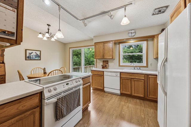 487 Lois Ln, Lino Lakes, MN 55014 - kitchen featuring white appliances, a textured ceiling, brown cabinetry, light wood-type flooring, and a chandelier