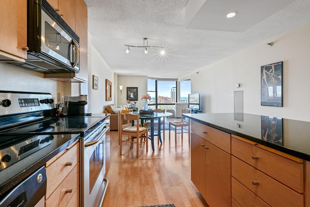 401 1st St Unit 1312, Minneapolis, MN 55401 - kitchen featuring appliances with stainless steel finishes, light wood-style floors, a textured ceiling, open floor plan, and expansive windows