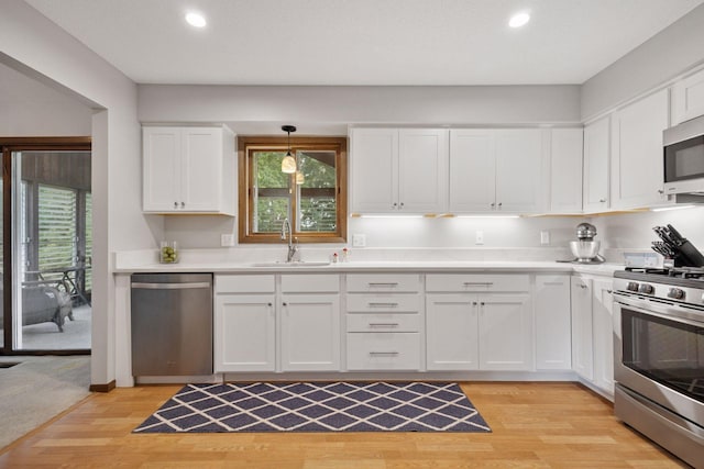 6240 Decatur Ave N, Brooklyn Park, MN 55428 - kitchen with appliances with stainless steel finishes, light wood-style floors, recessed lighting, white cabinets, and plenty of natural light