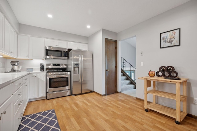 6240 Decatur Ave N, Brooklyn Park, MN 55428 - kitchen featuring appliances with stainless steel finishes, white cabinetry, light wood-type flooring, light countertops, and recessed lighting