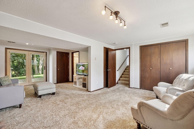 6240 Decatur Ave N, Brooklyn Park, MN 55428 - living room with light colored carpet, a textured ceiling, and stairway
