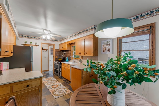 1228 Palace Ave, Saint Paul, MN 55105 - kitchen with stainless steel appliances, light countertops, ceiling fan, backsplash, and dark stone finish floors