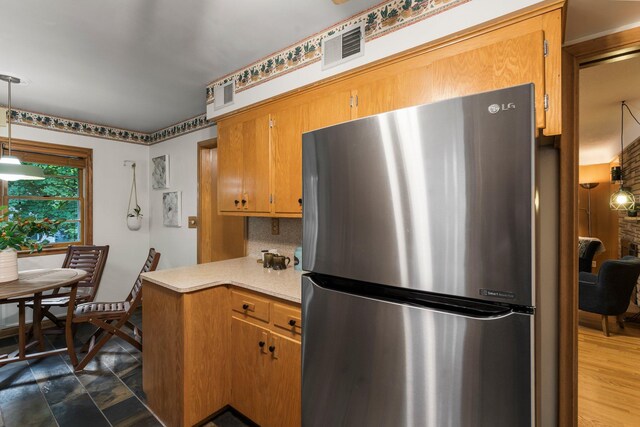 1228 Palace Ave, Saint Paul, MN 55105 - kitchen featuring freestanding refrigerator, light countertops, brown cabinetry, decorative backsplash, and hanging light fixtures