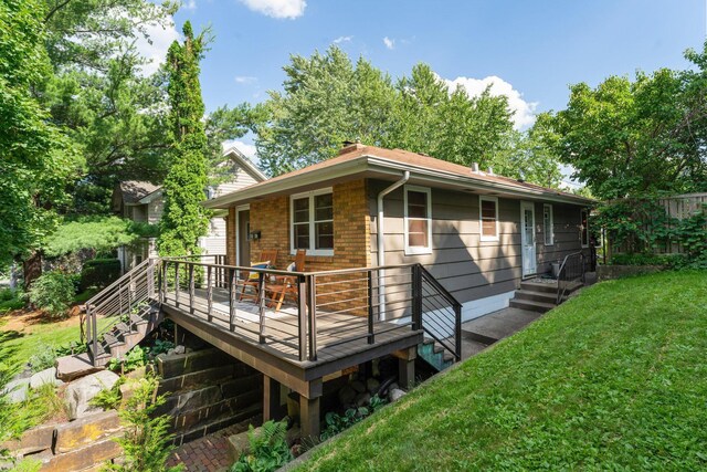1228 Palace Ave, Saint Paul, MN 55105 - rear view of house with a lawn, a deck, and brick siding