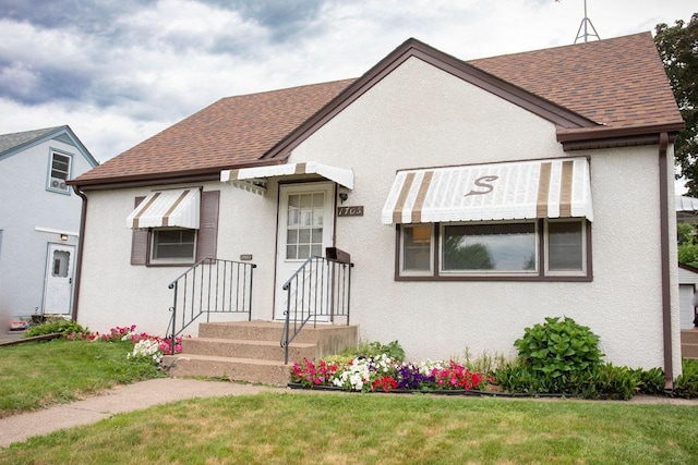 1705 California Ave E, Saint Paul, MN 55106 - tudor house with a shingled roof, a front lawn, and stucco siding