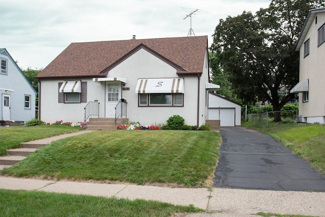 1705 California Ave E, Saint Paul, MN 55106 - english style home with a shingled roof, an outbuilding, a detached garage, and stucco siding