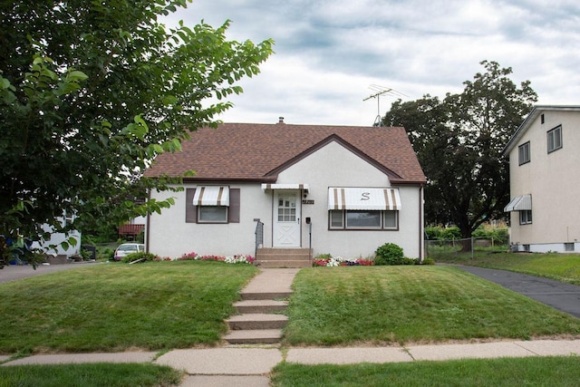1705 California Ave E, Saint Paul, MN 55106 - view of front facade featuring a front lawn and roof with shingles