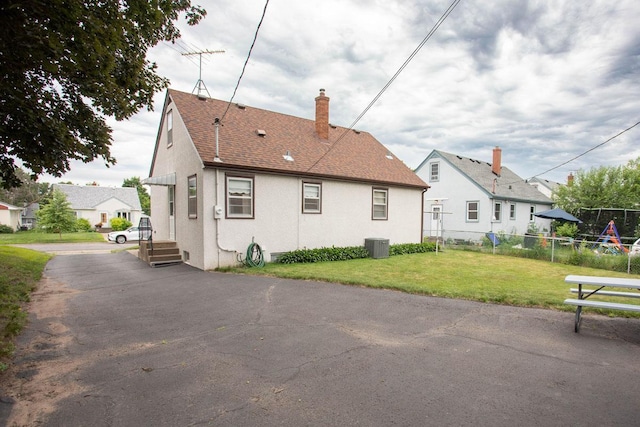 1705 California Ave E, Saint Paul, MN 55106 - back of property featuring a chimney, stucco siding, and roof with shingles
