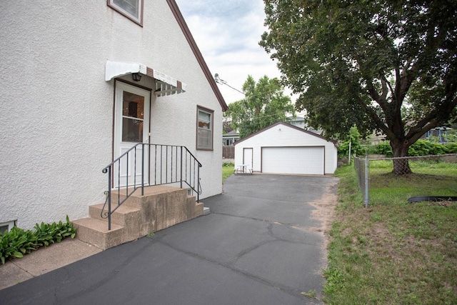 1705 California Ave E, Saint Paul, MN 55106 - view of side of property featuring stucco siding, an outbuilding, and a detached garage