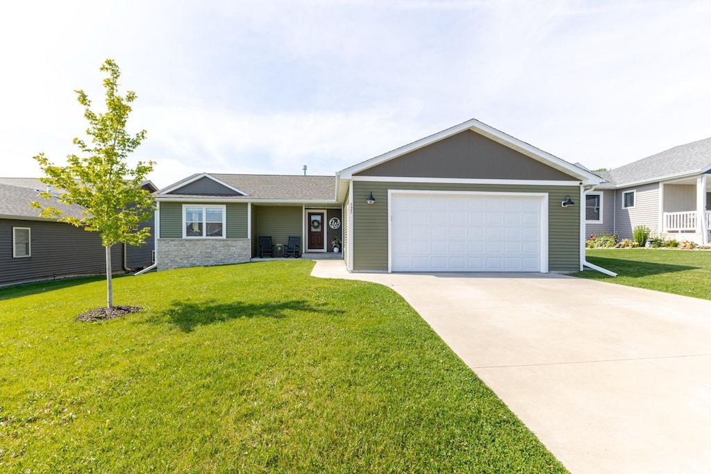 525 7th Ave NE, Plainview, MN 55964 - ranch-style home with an attached garage, concrete driveway, a front lawn, and stone siding