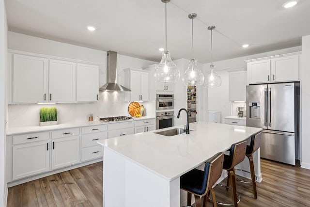 15101 Quince St NW, Andover, MN 55304 - kitchen featuring appliances with stainless steel finishes, wall chimney exhaust hood, wood finished floors, white cabinets, and recessed lighting