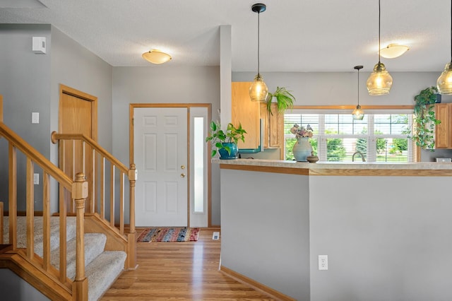 1358 Phalen Blvd, Saint Paul, MN 55106 - entrance foyer featuring light wood-style flooring, stairs, and a textured ceiling