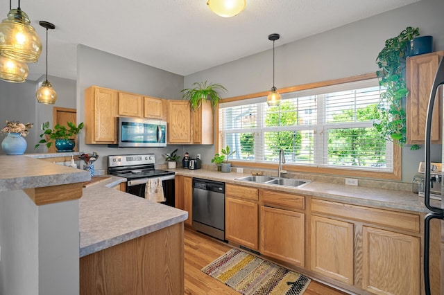 1358 Phalen Blvd, Saint Paul, MN 55106 - kitchen featuring stainless steel appliances, light wood-style flooring, light countertops, hanging light fixtures, and light brown cabinets