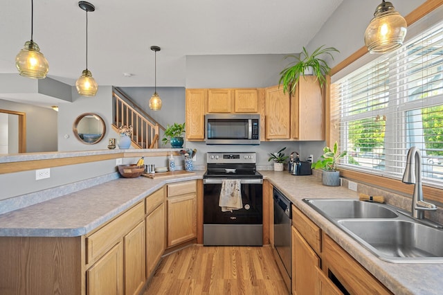 1358 Phalen Blvd, Saint Paul, MN 55106 - kitchen featuring appliances with stainless steel finishes, a peninsula, light wood-type flooring, hanging light fixtures, and light countertops