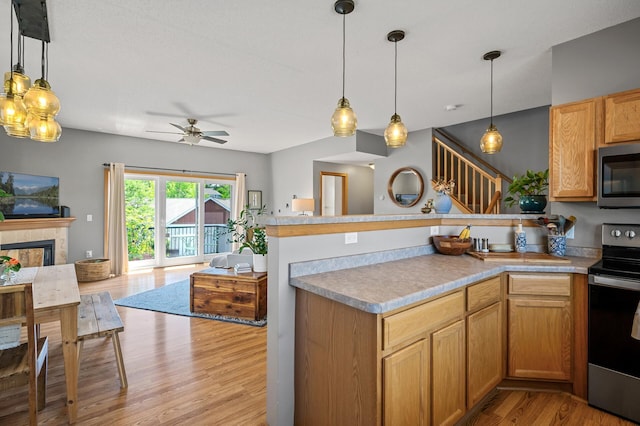 1358 Phalen Blvd, Saint Paul, MN 55106 - kitchen with stainless steel appliances, open floor plan, a peninsula, light wood-style floors, and a ceiling fan